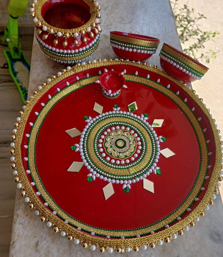 a red and gold tray with two bowls on it next to another bowl that is sitting on a table