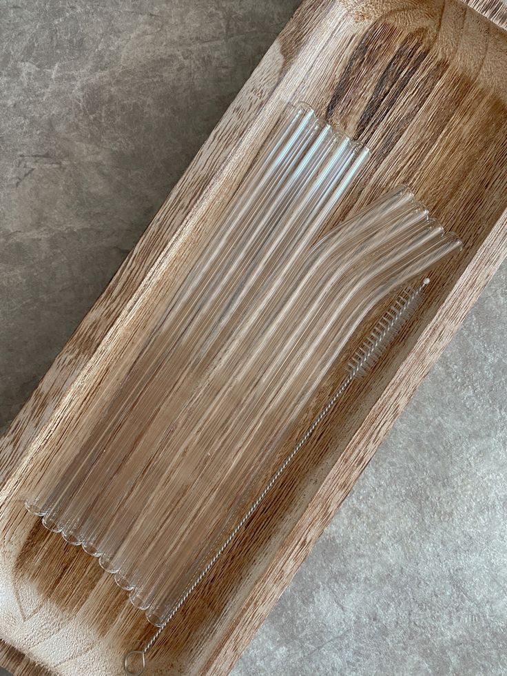 a wooden tray with some straws in it