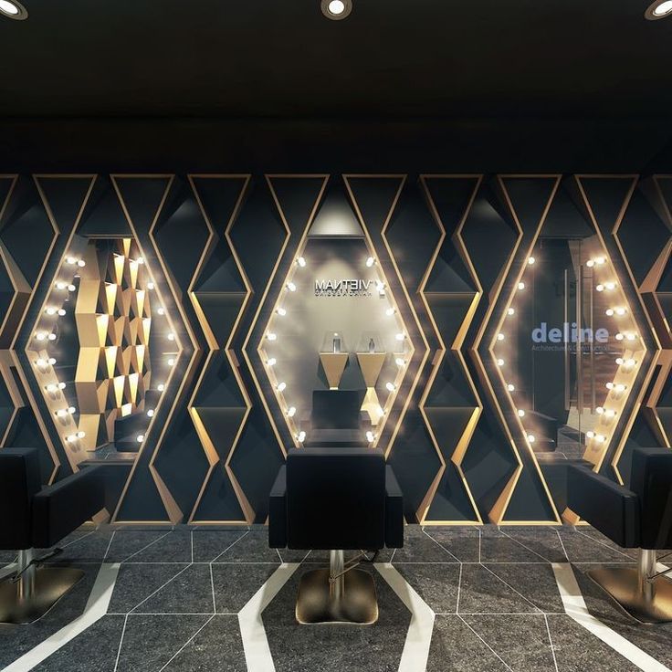 the interior of a hair salon with lights on the wall and chairs in front of it