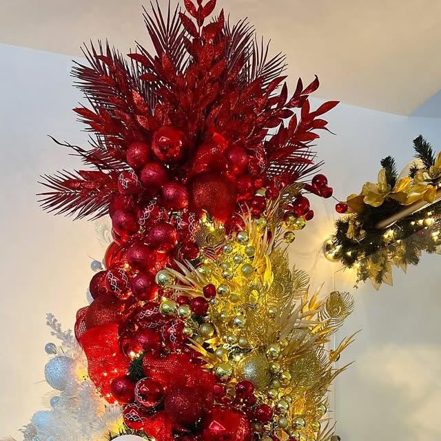 red and gold christmas decorations on display in a room