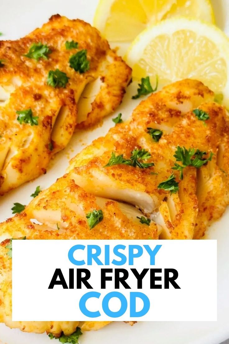 crispy air fryer chicken on a white plate with lemon wedges and parsley