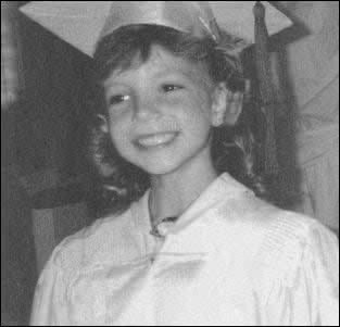 black and white photograph of a young boy in sailor's hat smiling at the camera