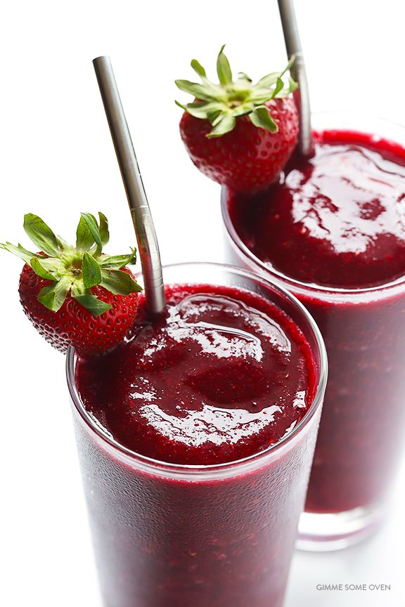 two glasses filled with red liquid and strawberries