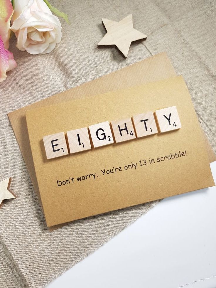 a piece of paper with the word eighty spelled on it next to flowers and star shaped magnets