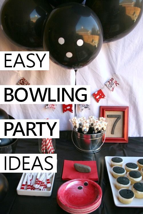 a table topped with black balloons and cupcakes