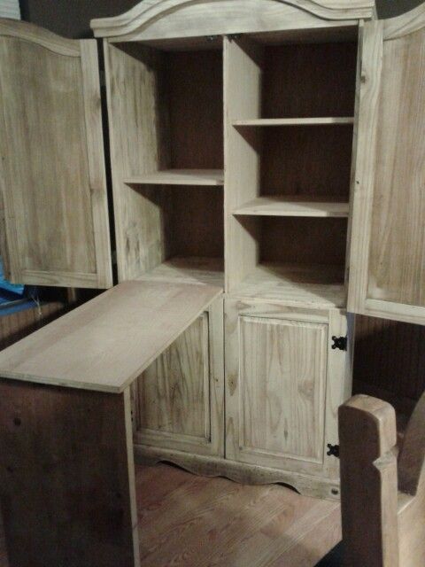 an old wooden cabinet with a desk and chair next to it in a room that is being remodeled