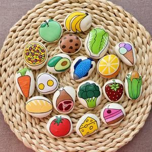 a wicker basket filled with lots of different types of decorated cookies on top of each other