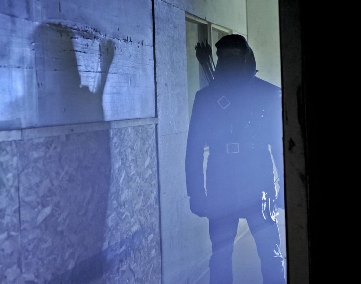 the shadow of a man standing in front of a wall with his back to the camera