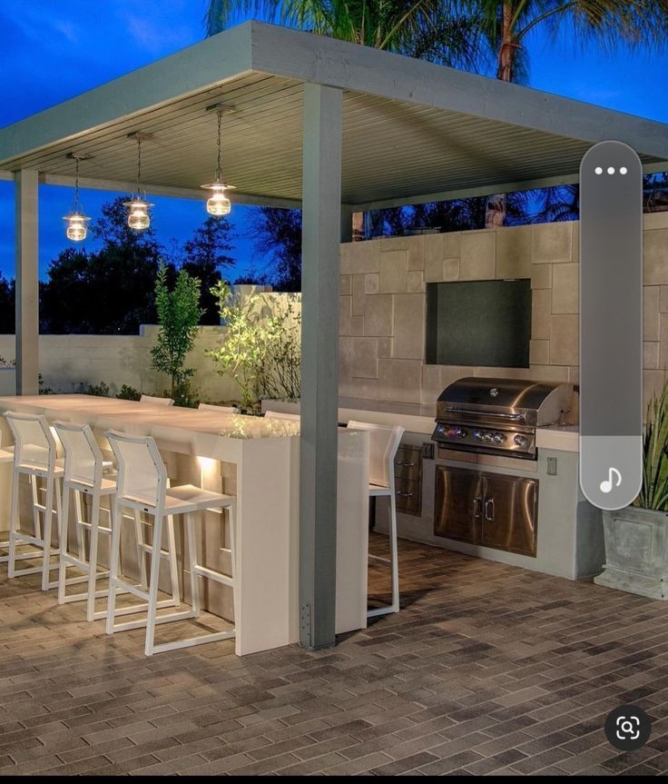 an outdoor kitchen with bar seating and grill