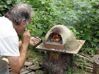 an old man is cooking something on the fire