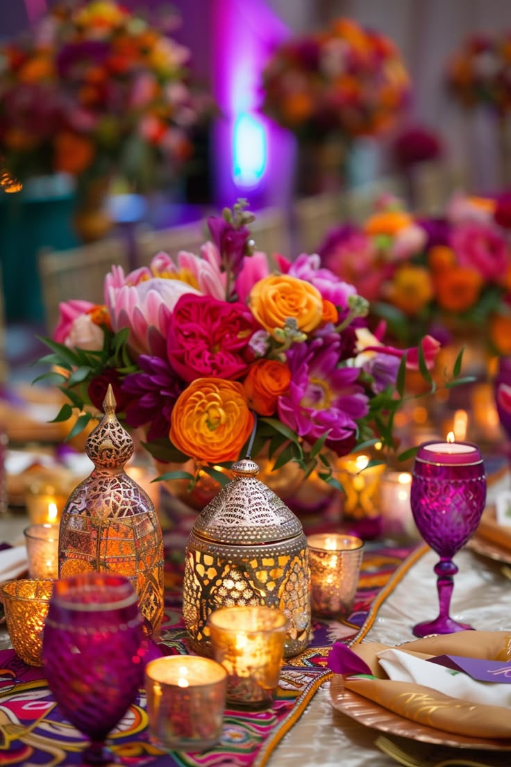 the table is set with candles, plates and vases filled with flowers on it