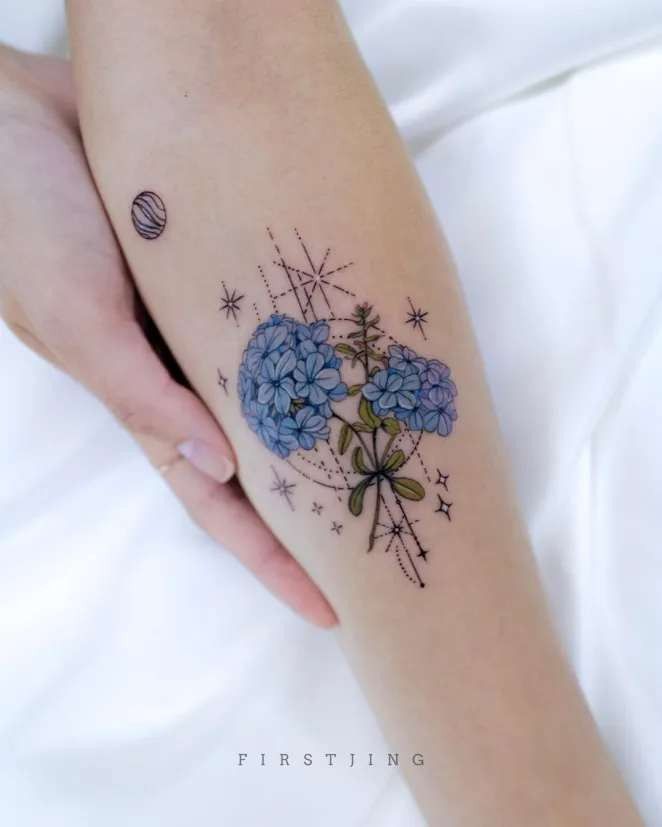 a woman's arm with blue flowers and stars tattooed on her left side leg