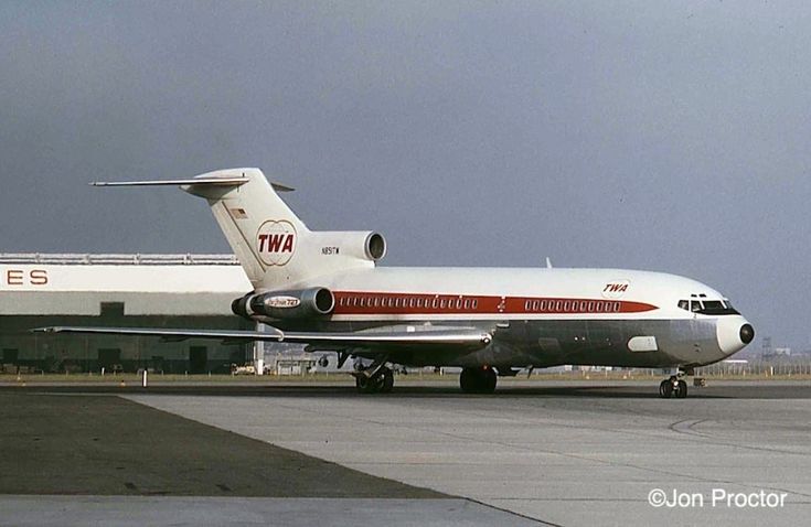 a red and white jet airliner sitting on top of an airport tarmac