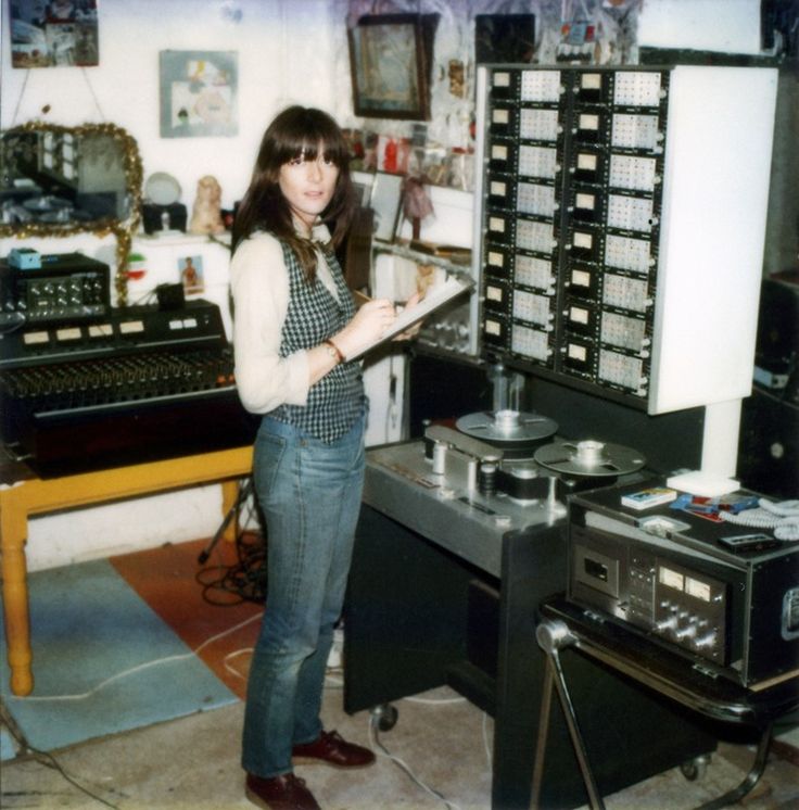 a woman standing next to a record player in a room