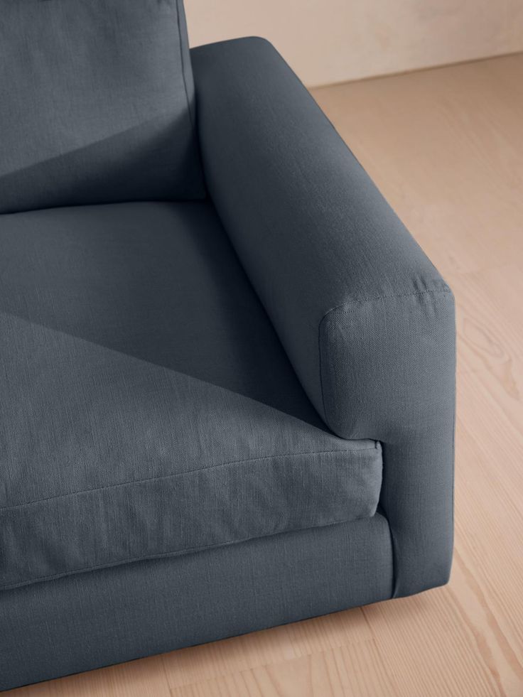 a blue couch sitting on top of a hard wood floor