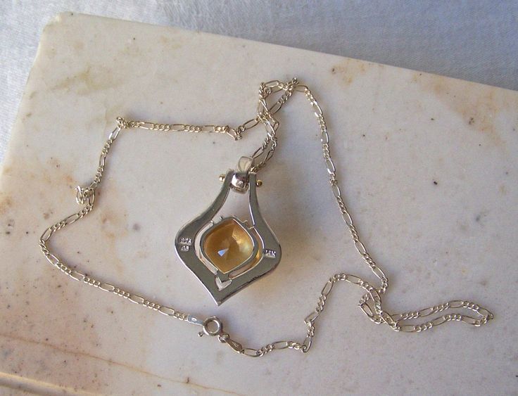 Vintage Sterling Necklace 14k Gold Accents Pendant 1990s. Featuring 15 ct Citrine Hexagon Gem Gift Idea for Mother Beautiful Sterling Silver Pendant Embellished with 14k Gold Accents sets off This Stunning 15 ct Hexagon Cut Citrine Gem. Very Large Citrine 15 ct Gem is in fine condition. No scratches or chips. Sterling silver chain necklace is 18 inches with a C clasp. Marked 925 Italy on chain clasp. Great Gift for Her, Mother's Day or Anniversary. Back of pendant is stamped 925 CS 14k The neckl Formal Hallmarked Pendant Jewelry, Formal Faceted White Gold Jewelry, Yellow Polished Necklace For Anniversary, Formal Amber Necklace In Fine Jewelry Style, Art Deco Cabochon Jewelry For Formal Occasions, Art Deco Cabochon Jewelry For Formal Events, Formal Citrine Jewelry With Diamond Cut, Fine Jewelry With Cabochon Drop, Amber Necklace With Polished Finish For Anniversary