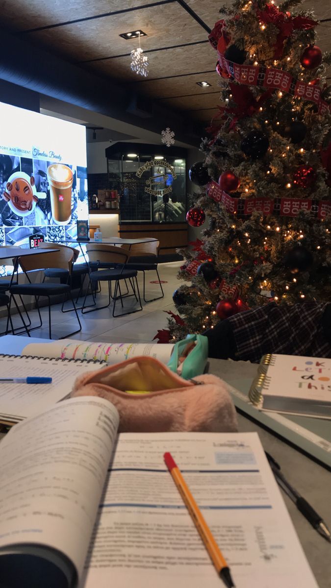 a christmas tree in the middle of a room with papers and pencils next to it