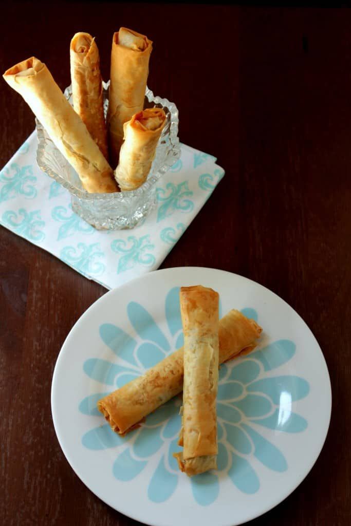 two plates with pastries on them sitting on a wooden table next to each other