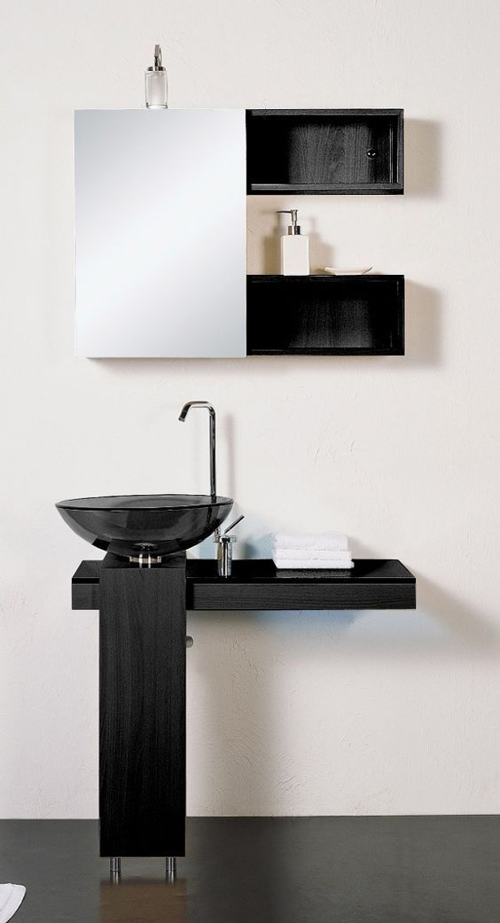 a bathroom sink sitting under a mirror next to a black counter top with two shelves above it