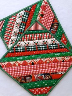 a quilted patchwork piece with red, green and white designs on it's edges