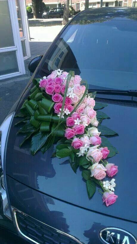 pink and white flowers on the hood of a car