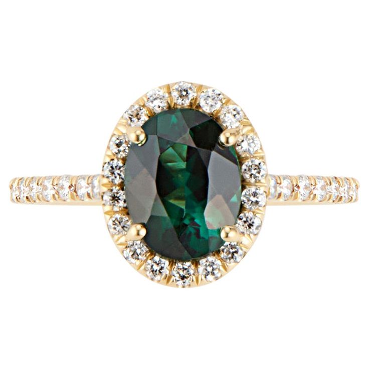 Eye Catching Oval Shaped Green Tourmaline set in a sparkling halo of diamonds in a high polish 18k Yellow Gold Ring. This stunning tourmaline was hand selected for its brilliance, clarity, and attractive bluish green hues. Handset in a delicate setting with a halo of VS quality diamonds, to create a sparkling contrast to the tourmaline hues. Green Tourmaline is believed to promote healing, harmony, and prosperity. Tourmaline has a hardness of 7 to 7.5 on Mohs Scale, so whilst it durable enough for everyday wear it is not as hard as a Diamond or Sapphire and can scratch if abused. Size 6 - can be resized 5.5 -6.5. Detailed Information: Green Tourmaline: 1.46 ctw Primary Stone Size: 8x6 Diamond: .42ctw Secondary Stone Size: 1.25mm (42) Approx. Shank Base Thickness:1.5 mm Antique Cocktail Ring, Sapphire Cocktail Ring, Montana Sapphire Ring, Contemporary Engagement Rings, Green Tourmaline Ring, Green Ring, Diamond Cocktail Rings, Gold Ring Sets, 18k Yellow Gold Ring