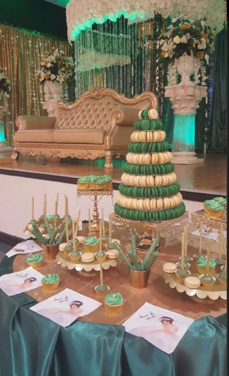 a table topped with cupcakes covered in green frosting and decorated like a christmas tree