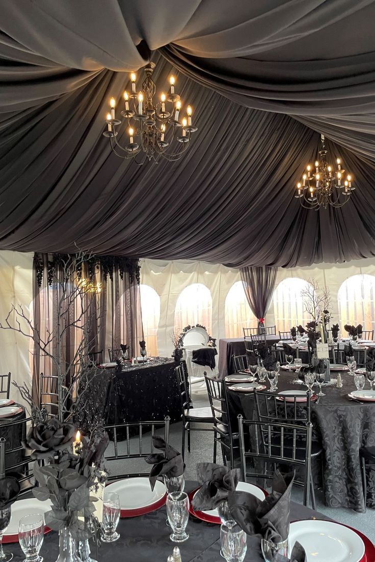 the tables are set up with black and white linens for an elegant dinner party