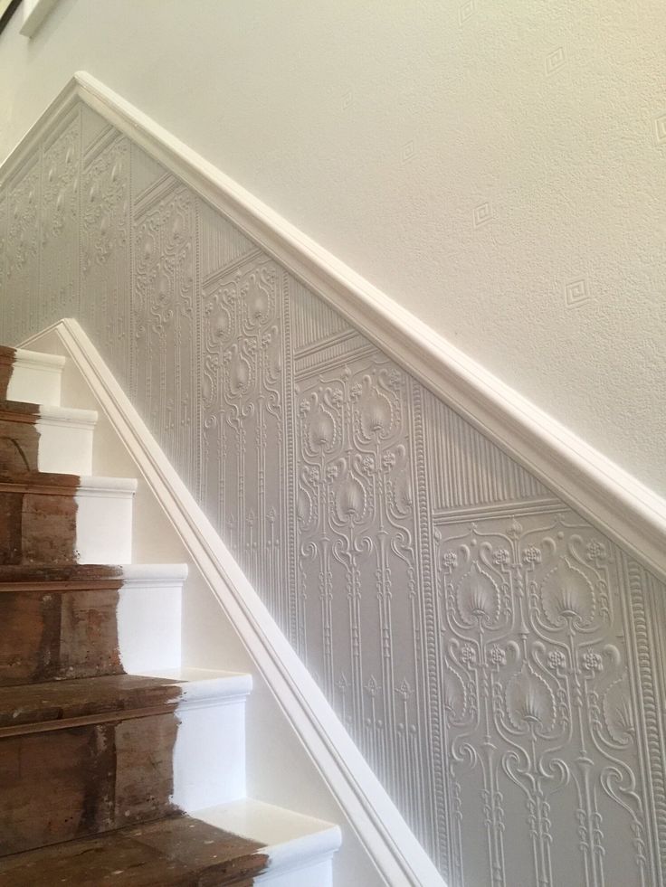 the stairs are painted white with decorative wallpaper