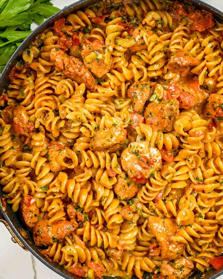 a skillet filled with pasta and meatballs