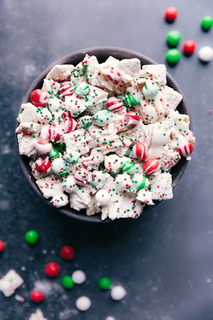 a bowl filled with candy canes and marshmallows on top of a table