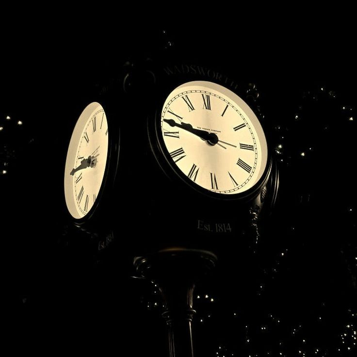 two clocks are lit up in the dark with stars around them and one is showing three o'clock