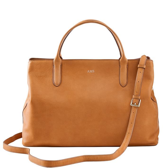 Super-functional and decidedly beautiful, the Caroline Leather Handbag is the ultimate work carryall. Spacious enough to fit a 13" laptop and everything else you need from 9 to 5, this versatile bag goes with everything, making it the perfect addition to your work wardrobe. Swap out the matching leather crossbody strap for one of our many colorful straps to create your own style.    17"w x 6"d x 11.25"h  Leather with a soft linen lining and gold-toned hardware.  See Product Information for more Leather Top Handle Laptop Bag For Work, Everyday Weekender Bag With Top Handle And Adjustable Strap, Everyday Timeless Leather Laptop Bag, Classic Shoulder Bag With Detachable Handle For Everyday Use, Timeless Leather Laptop Bag For Everyday, Classic Everyday Laptop Bag With Top Handle, Classic Everyday Tote Laptop Bag, Timeless Everyday Tote Briefcase, Classic Everyday Laptop Bag With Top Carry Handle