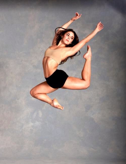 a woman is jumping in the air while wearing a swimsuit