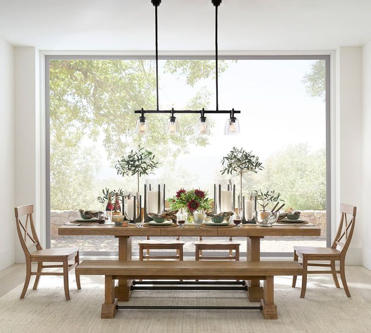 a dining room table and chairs with candles on them in front of a large window