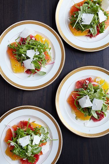 four white plates with different types of food on top of each other and one is filled with watermelon