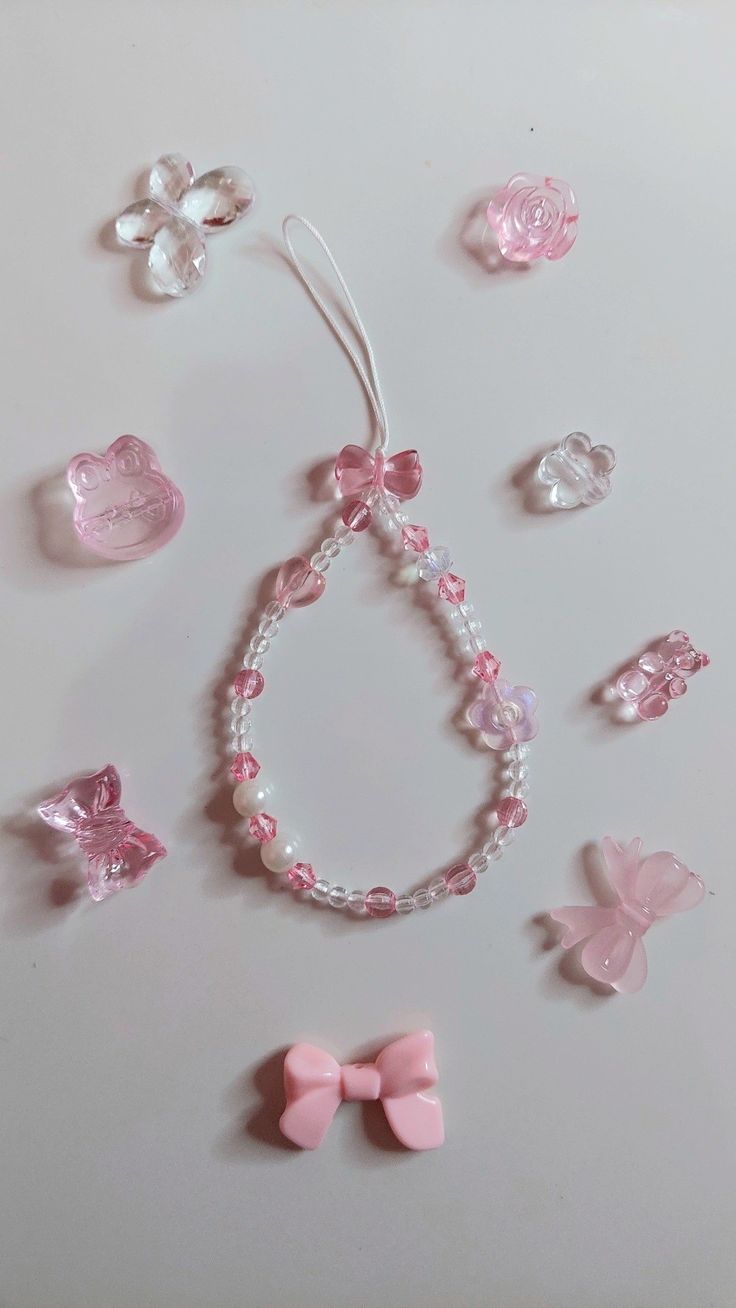 pink and white beads with bows, pearls and other accessories laid out on a table