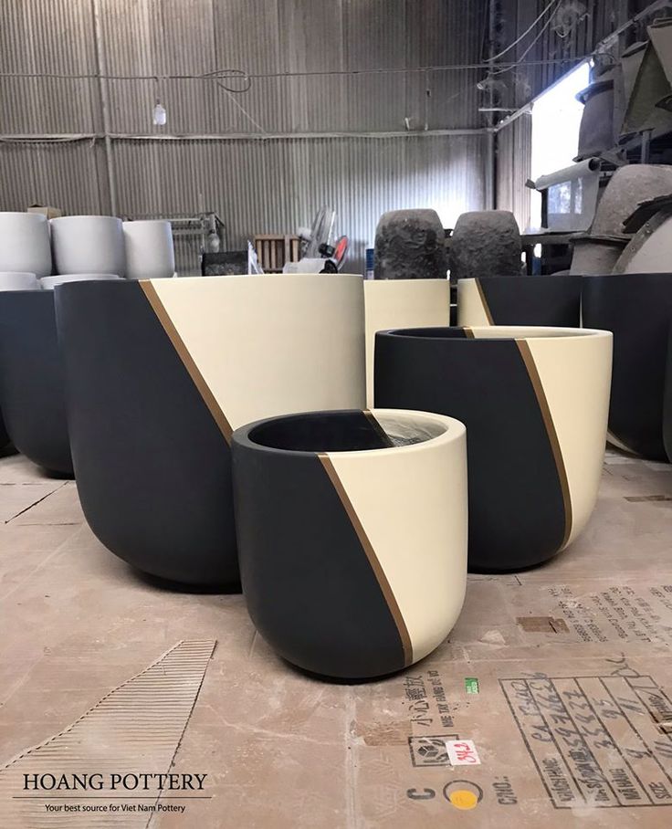 several black and white planters sitting in a warehouse