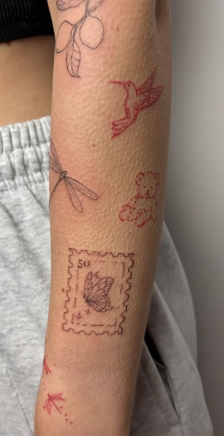 a woman's arm with tattoos on it, including a stamp and dragonflys