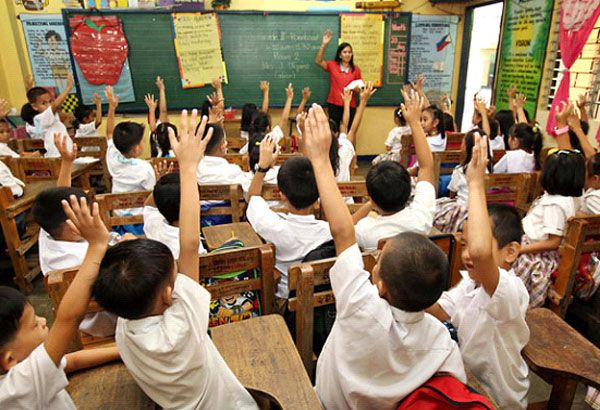 many children are raising their hands in the classroom