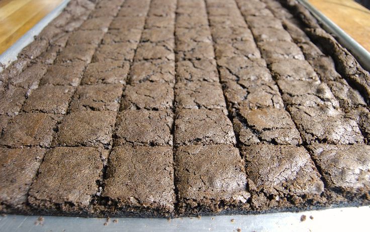 an industrial conveyor belt with brownies on it's sides, ready to be processed