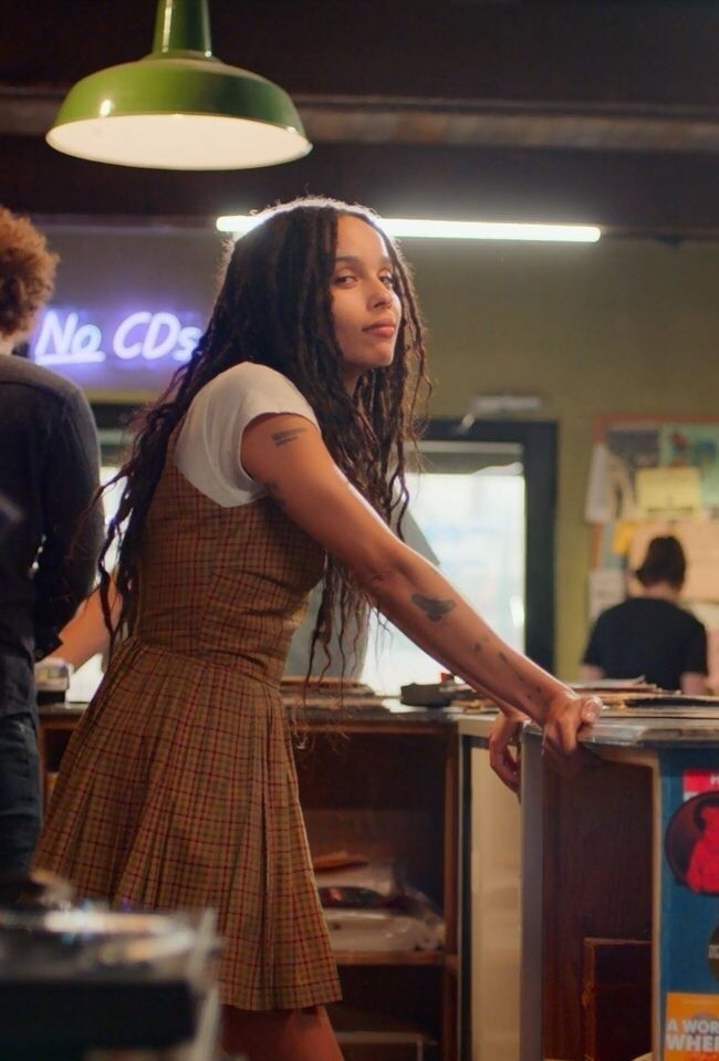 a woman with dreadlocks standing at a counter