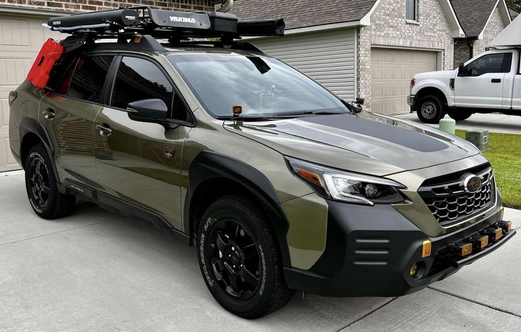 a silver and black suv parked in front of a house