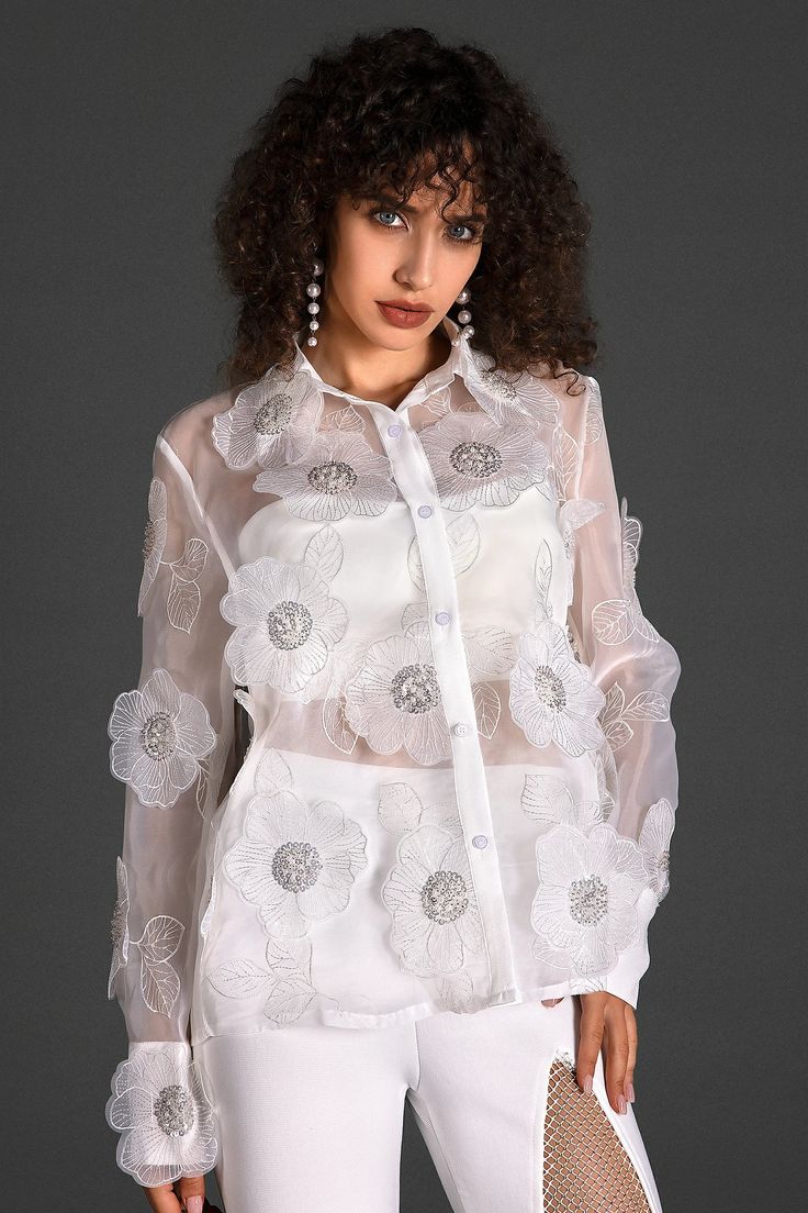 Step into a world of style with our organza embroider floral shirt. This shirt boasts intricate floral embroidery on delicate organza fabric, exuding modern elegance and charm. The addition of transparent elements adds a subtle allure, ensuring you radiate charm and confidence at every event. Handmade customization Fabric composition: 90% polyester fiber, 10% spandex Washing method: hand wash or dry clean Popular elements: organza Spring Long Sleeve Embellished Shirt, Spring Embellished Fitted Shirt, Elegant Embellished Spring Shirt, Elegant Embellished Summer Shirt, Elegant Long Sleeve Shirt With Floral Embroidery, Elegant Summer Organza Tops, White Organza Evening Top, Spring Long Sleeve Organza Blouse, Chic Floral Embroidered Shirt For Spring