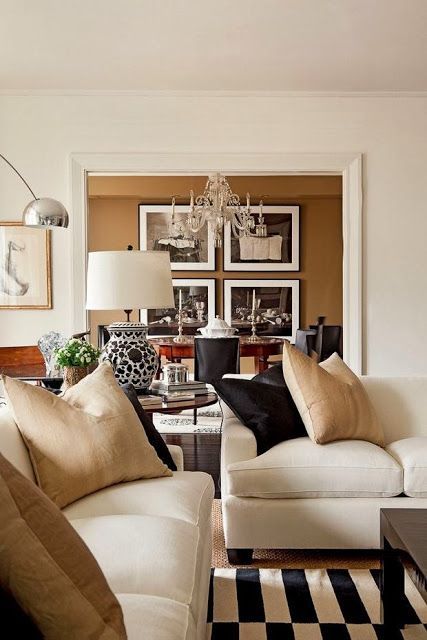 a living room filled with furniture and a chandelier hanging from the ceiling over a black and white checkered floor