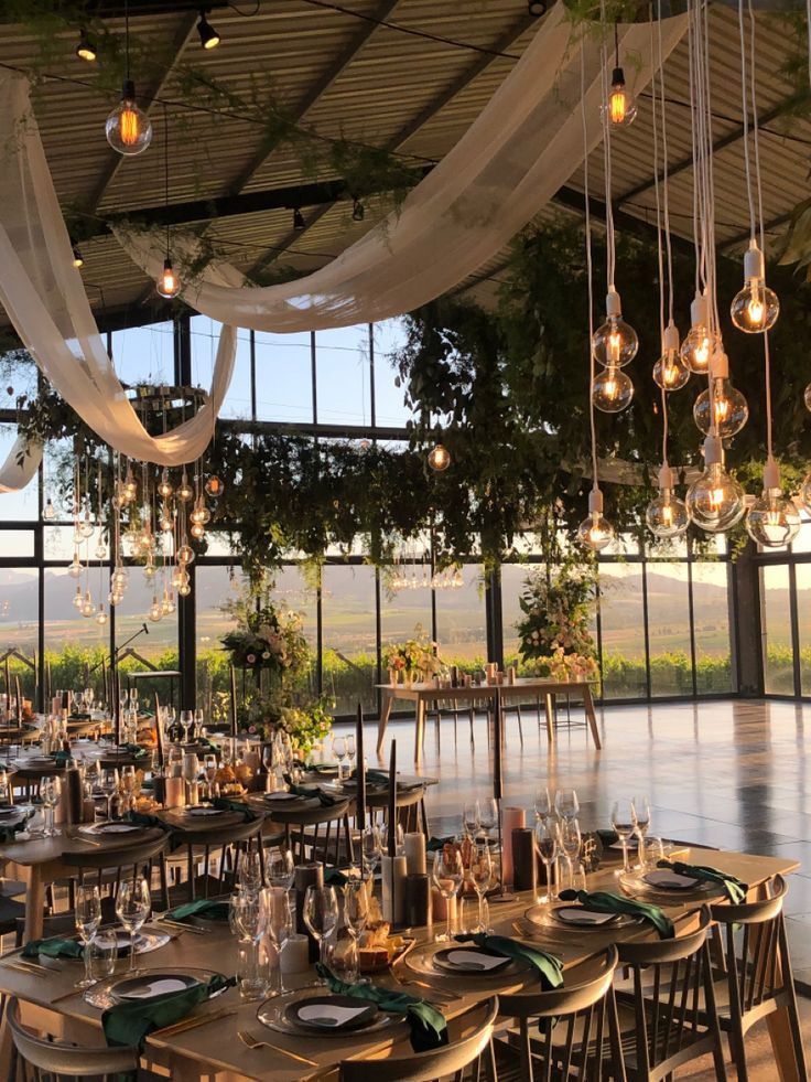 an indoor dining area with lots of tables and chairs set up for a formal function