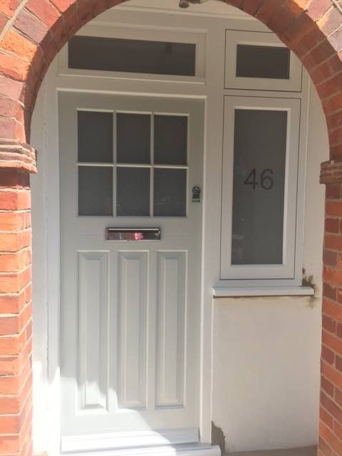 a white front door with a brick arch