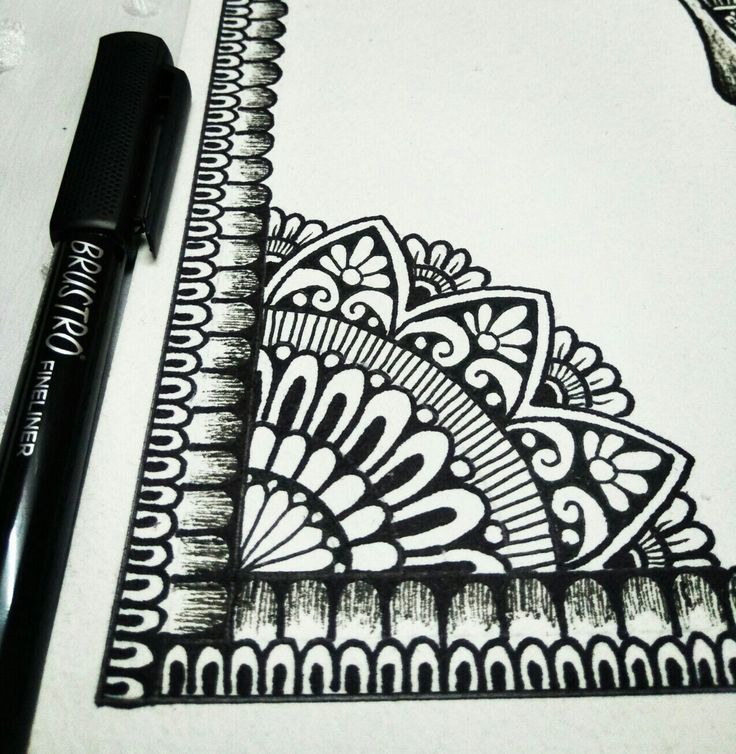 a pen is sitting on top of a paper with an intricate design in black and white