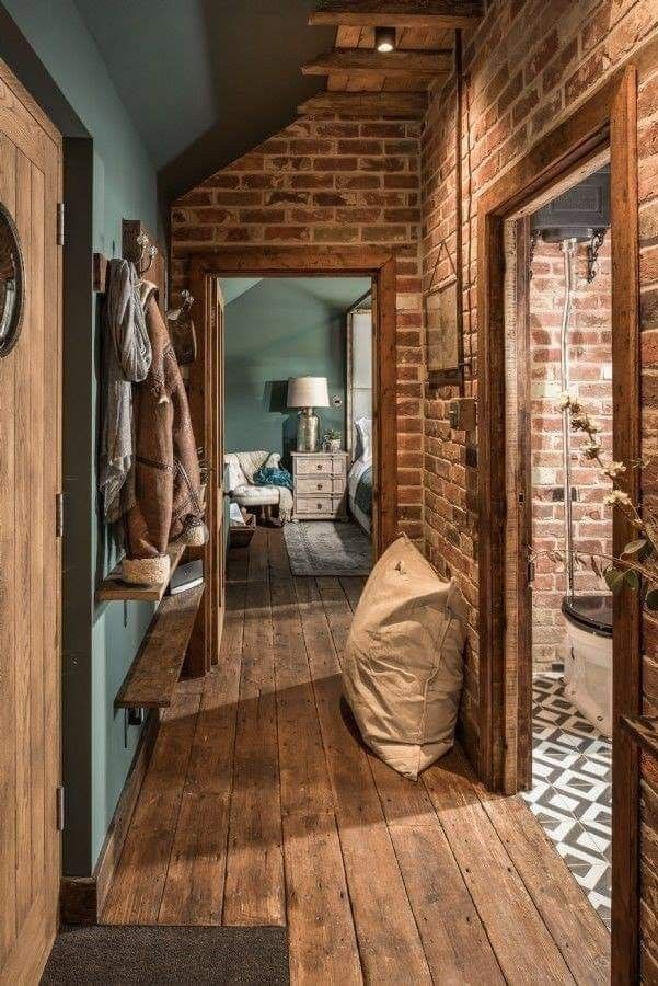 a hallway with wooden floors and brick walls