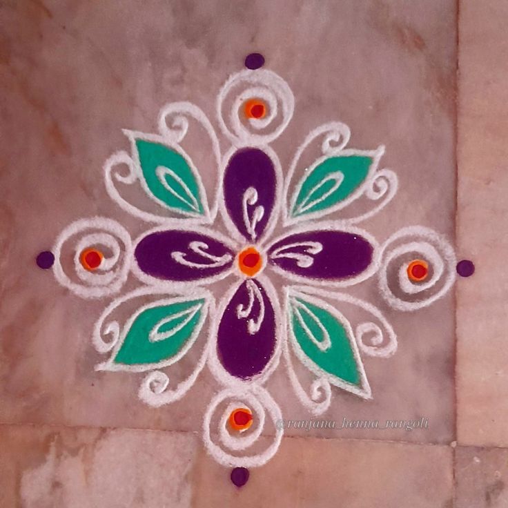 an artistic design on the ground in white and purple with green leaves painted on it